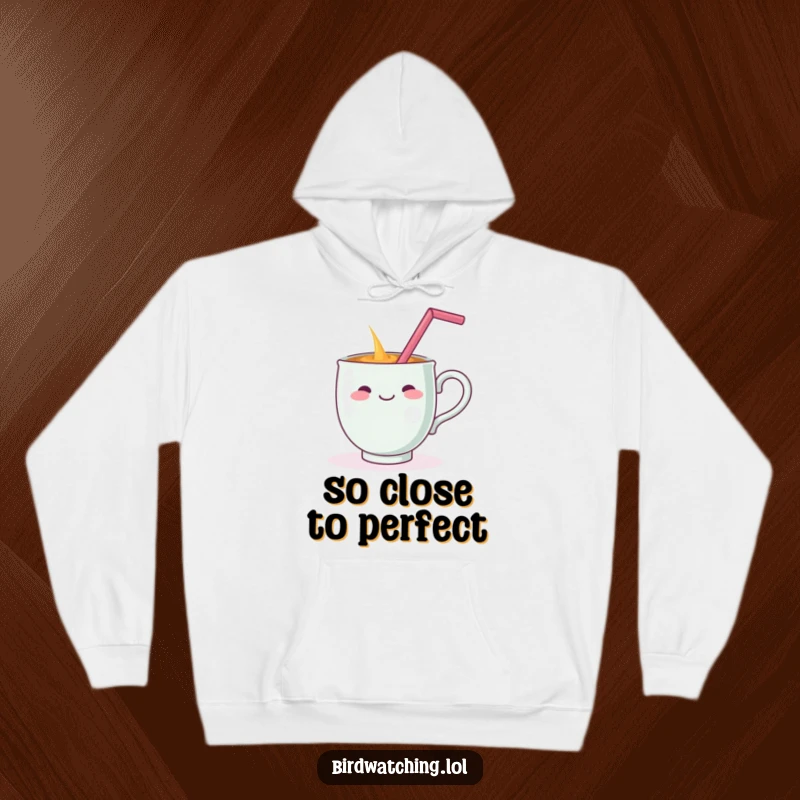 Funny hoodie showing a cheerful teacup dramatically spilling its drink while balancing a straw on its handle, a humorous depiction of a toppled beverage.